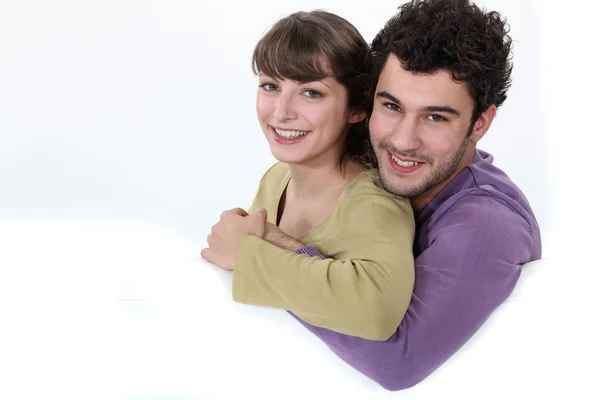 Пара обіймає білий диван — стокове фото