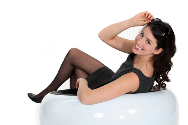 Brunette vrouw zit in witte stoel — Stockfoto