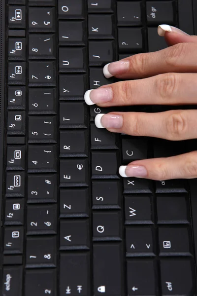 Manicured hand using a computer keyboard — Stock Photo, Image