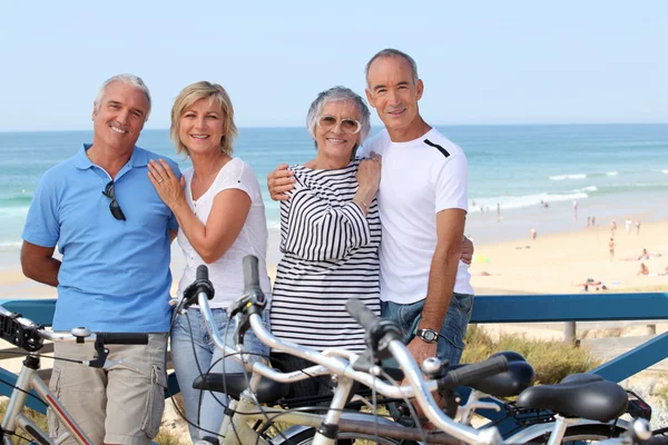Retrato de quatro na praia com bicicletas — Fotografia de Stock