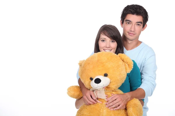 Adolescente casal com um grande urso de pelúcia — Fotografia de Stock