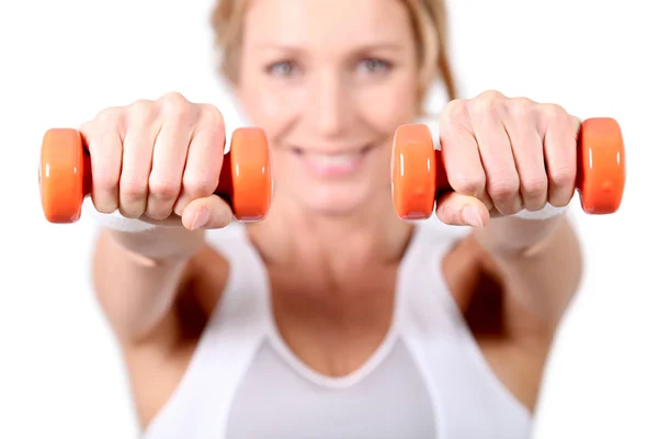 Женщина с помощью гирь для рук во время занятий фитнесом — стоковое фото