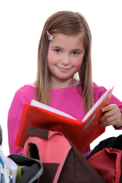 Schoolmeisje verwijderen boek uit rugzak — Stockfoto