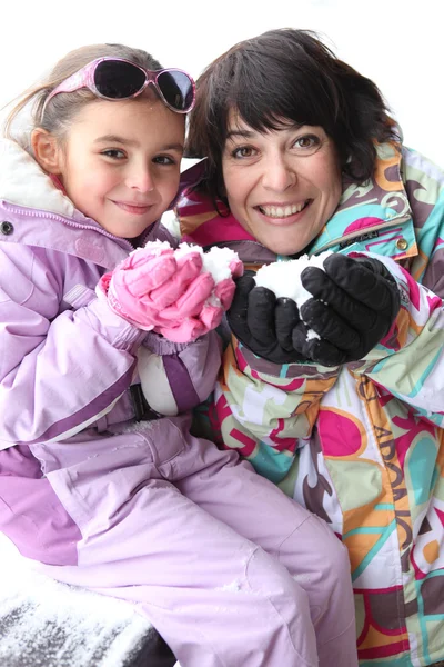 Anne ve kızı birlikte karda oynarken — Stok fotoğraf