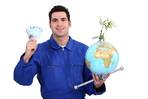Mechanic met contant geld en een globe — Stockfoto