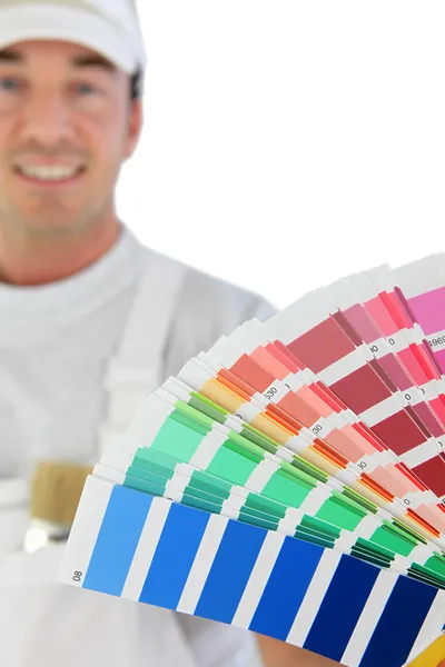 Мужчина-декоратор держит образцы краски — стоковое фото