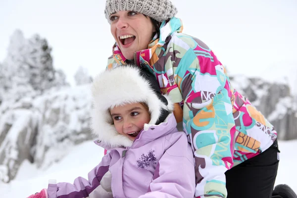 Mutter und Tochter spielen im Schnee — Stockfoto
