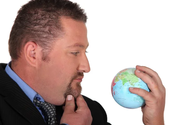 Homme d'affaires regardant un globe — Photo