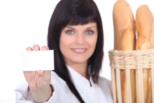 Woman baker showing businesscard — Stock Photo, Image