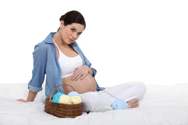 Sevimli kadın bekliyor bebek yün topları tarafından çevrili — Stok fotoğraf