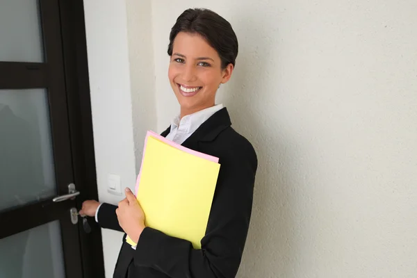 Female estate agent putting key in door — Stock Photo, Image