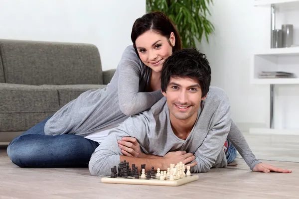 Couple sat at home playing chess — Stock Photo, Image