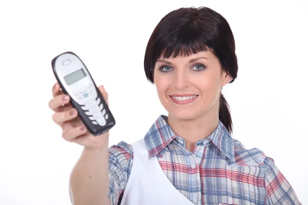 Домохозяйка держит мобильный телефон — стоковое фото