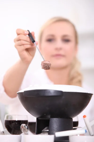 Kobieta jedzenie fondue bourguignonne — Zdjęcie stockowe