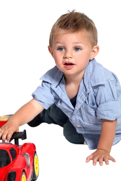 Ένα μικρό αγόρι που παίζει με ένα αυτοκίνητο. — Φωτογραφία Αρχείου