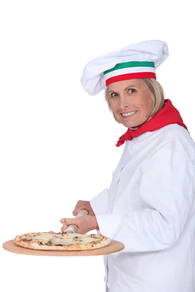 Старшая кухарка готовит пиццу — стоковое фото