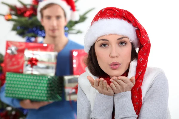 Frau mit Weihnachtsmütze bläst Kuss — Stockfoto