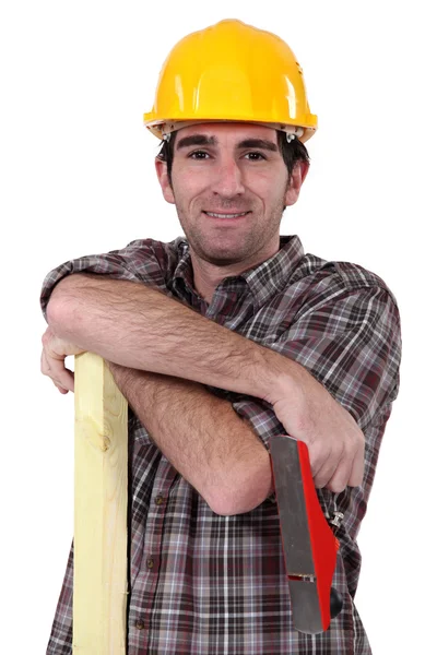Tradesman holding a wooden plank and a plane — Stock Photo, Image