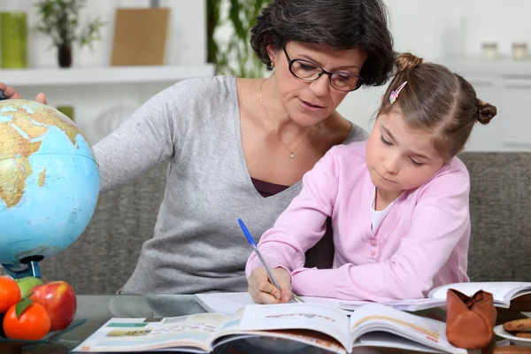 Mother teaching daughter from home Stock Image