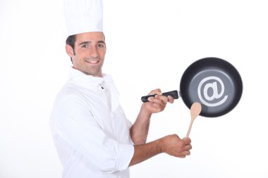 Chef holding pan in studio clipart