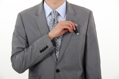 A businessman putting his Usb key in his pocket. clipart