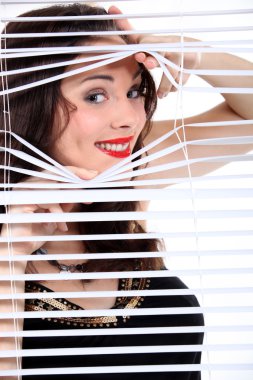 Sexy woman looking through the blinds clipart