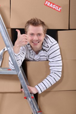 Factory worker emerging from cardboard boxes clipart