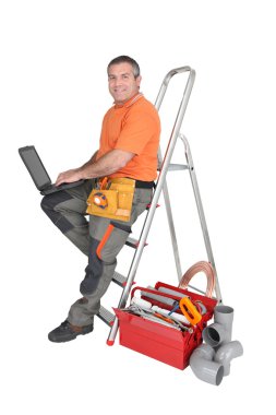 Builder typing on a laptop clipart