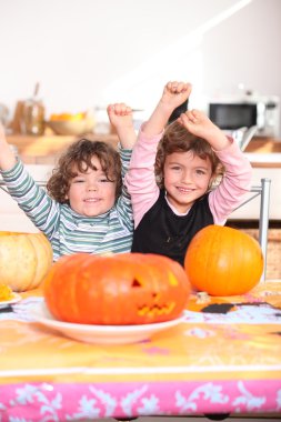 Happy children with carved pumpkins clipart