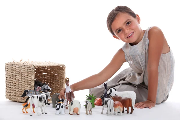 Klein meisje spelen met speelgoed dieren — Stockfoto