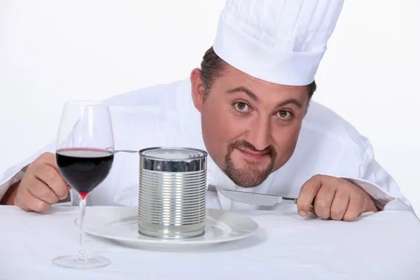 Chef-kok met glas wijn en tin van levensmiddelen — Stockfoto