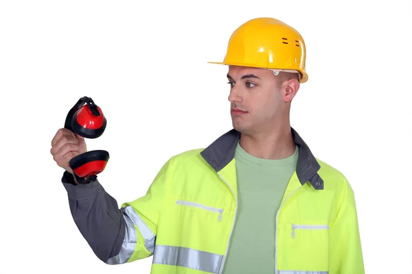 Bauarbeiter starrt auf seine Ohrenschützer — Stockfoto