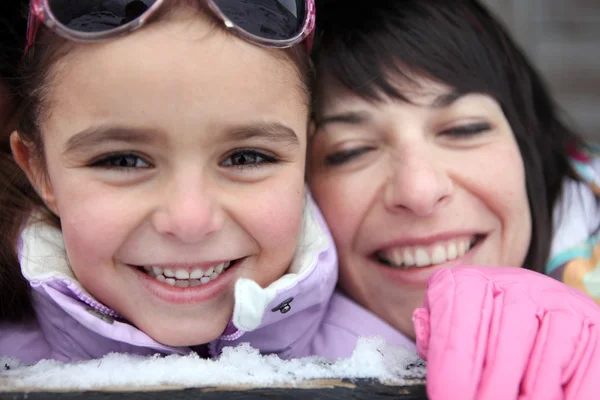 Madre e hija riéndose en la nieve —  Fotos de Stock