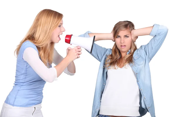 Meisjes schreeuwen in een bullhorn en meisje die betrekking hebben op haar oren — Stockfoto