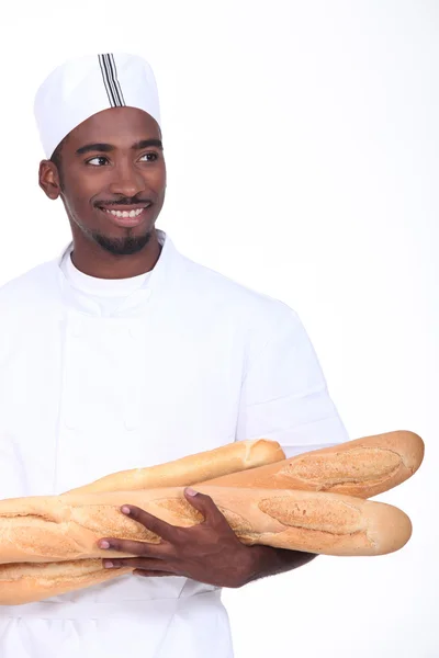 Panadero con un brazo de baguettes —  Fotos de Stock