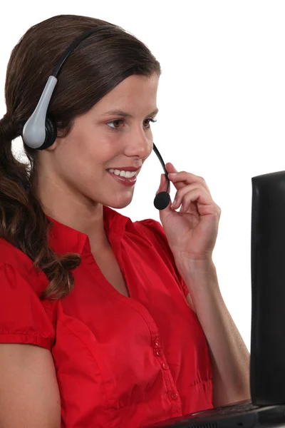 Kvinna med en bärbar dator och headset — Stockfoto