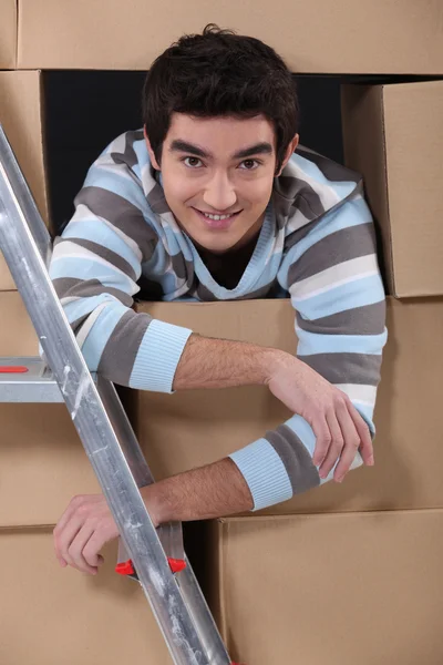 Rapaz cercado por caixas de papelão — Fotografia de Stock