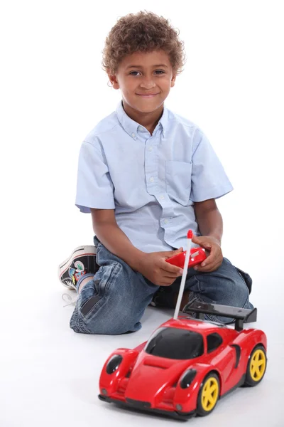 Een jongen speelt met een radio control auto — Stockfoto