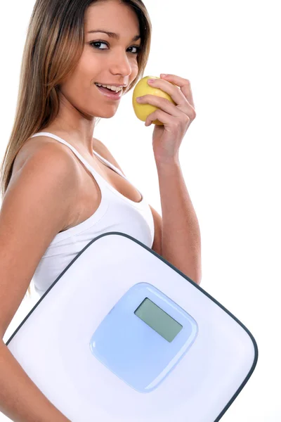 Kobieta trzyma jabłko i łazienka wagi — Zdjęcie stockowe
