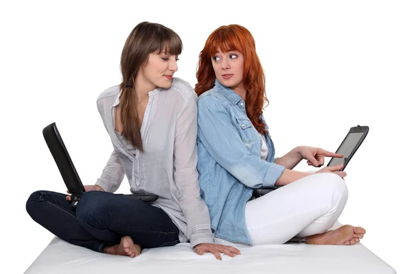 Dos amigos espalda con espalda sobre sus computadoras portátiles . — Foto de Stock