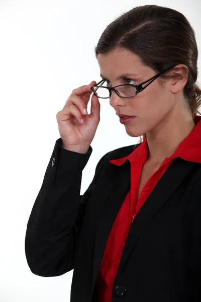 Seriös affärskvinna lyftande glasögon — Stockfoto