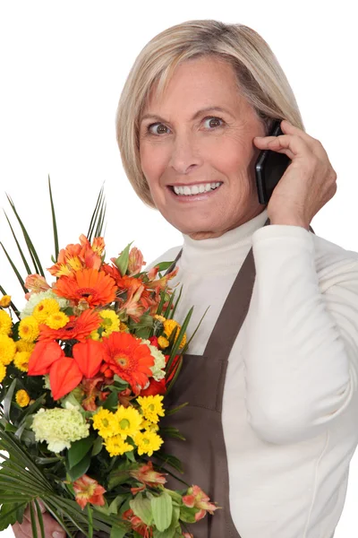 Reife Blumenhändlerin mit Blumenstrauß — Stockfoto