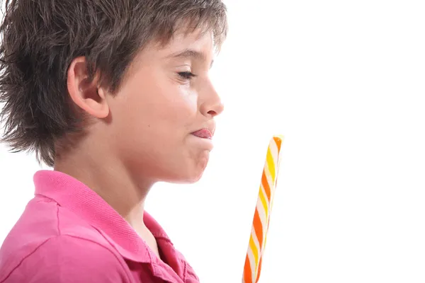 Młody chłopak lizanie wargi na widok jego lollypop — Zdjęcie stockowe
