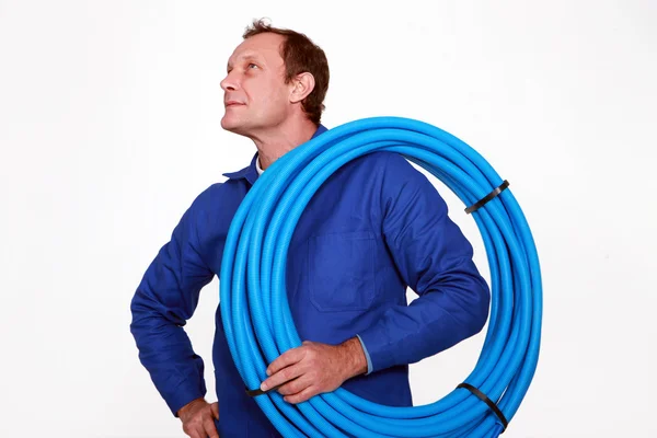 Rörmokaren med en rulle av blå rör — Stockfoto