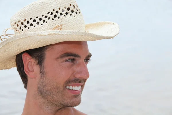 Młody człowiek z Słomkowy kapelusz pozowanie profil — Zdjęcie stockowe