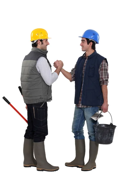 Dos trabajadores de la construcción saludándose — Foto de Stock