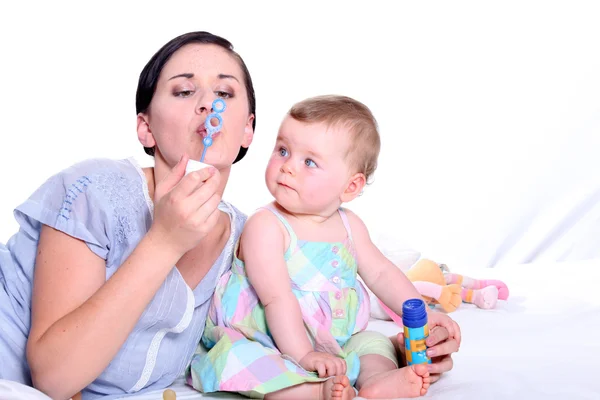 Matka a dítě vyfukuje bubliny dohromady — Stock fotografie