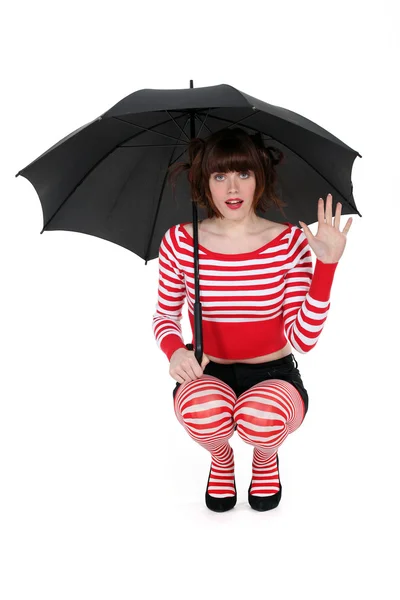 Mujer arrodillada con paraguas — Foto de Stock