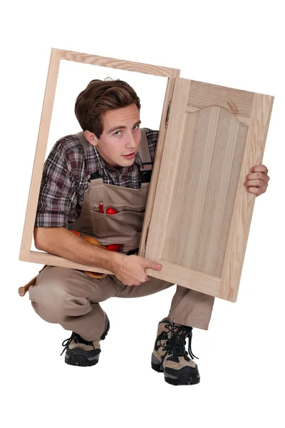 Carpinteiro com porta do armário — Fotografia de Stock