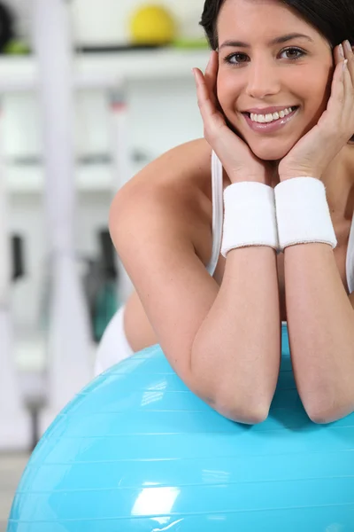 Vrouw in gym met blauwe bal met het — Stockfoto
